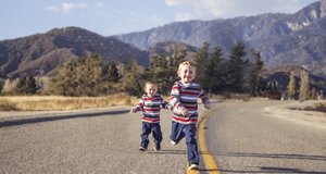 Zwei kleine Jungen laufen eine Straße entlang